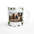 Mug with a family photo printed on it, surrounded by eucalyptus leaves.