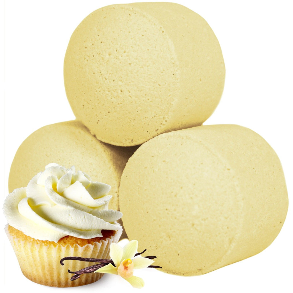 Three yellow bath bombs with a vanilla cupcake and vanilla bean on a white background