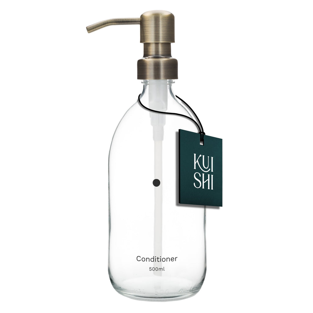 Clear glass bottle with metallic pump and 'Kushi' label on a white background