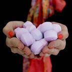 Black Cherry Chill Pills Bath Bombs Gift Box - 1.3Kg & hands holding purple marshmallows against a dark background