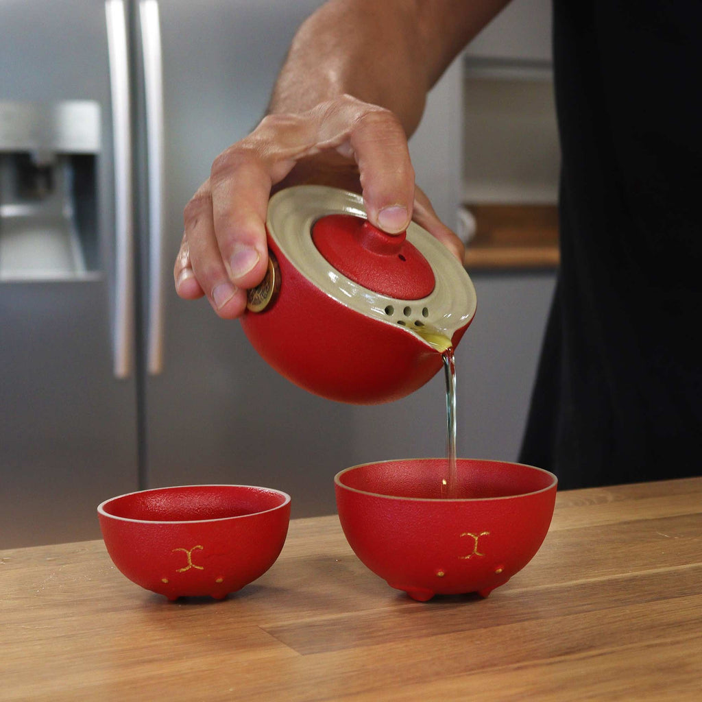 Money Cat Teapot Set - Two Cups - Travel Pack - Red, pouring tea from red teapot into matching cups.