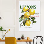 Poster of lemons on a wall above a table with chairs in a room.