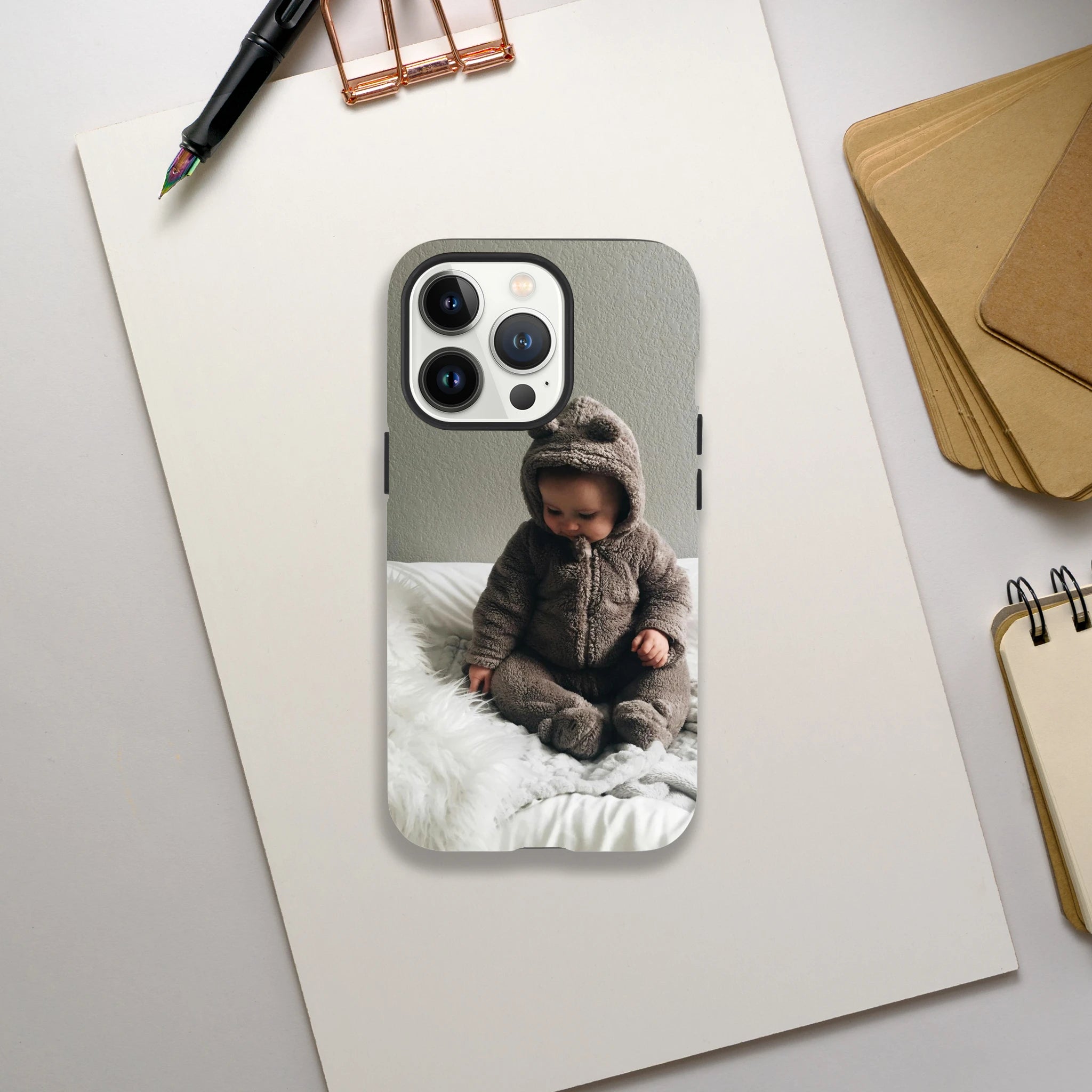 Personalised Photo Tough Case iPhone 13 Pro Max with a child in a bear costume on a desk with stationery items.