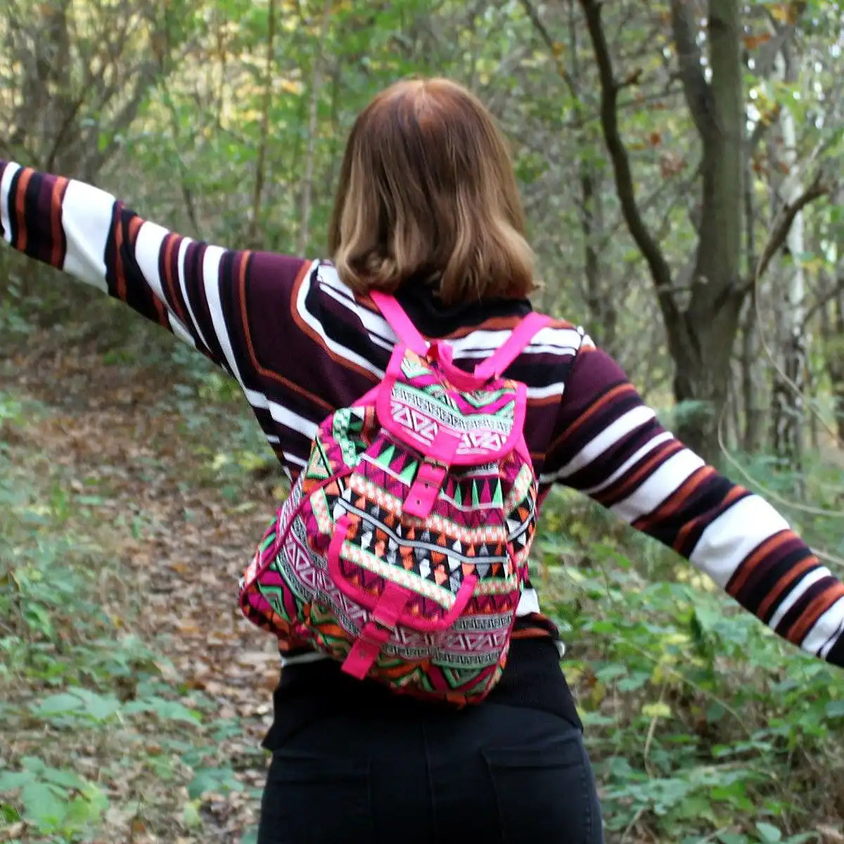 Person with a colorful Pink Backpack Jacquard Bag in a forest