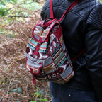 Person wearing a patterned Red Backpack Jacquard Bag in a forest setting