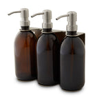 Three amber glass bottles with silver pump dispensers on a white background