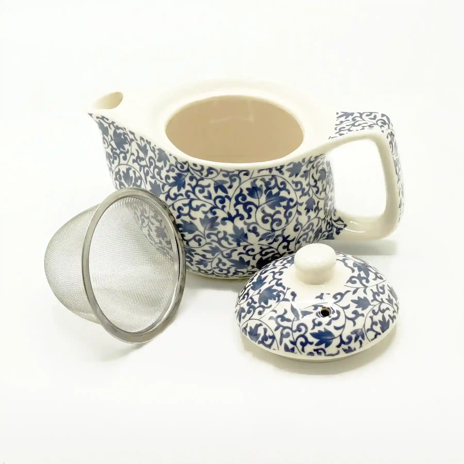 Ceramic teapot with blue floral patterns, lid, and mesh filter on a white background