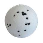 White bath bomb with black specks on a white background