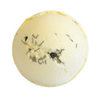 Bath bomb with visible herbs on a white background