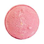 Pink bath bomb with specks on a white background