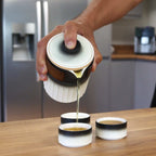 Travel Ceramic Teapot Set - Travel Pack pouring tea into cups on a wooden table.