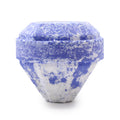 Blue and white textured diamond-shaped bath bomb on a white background