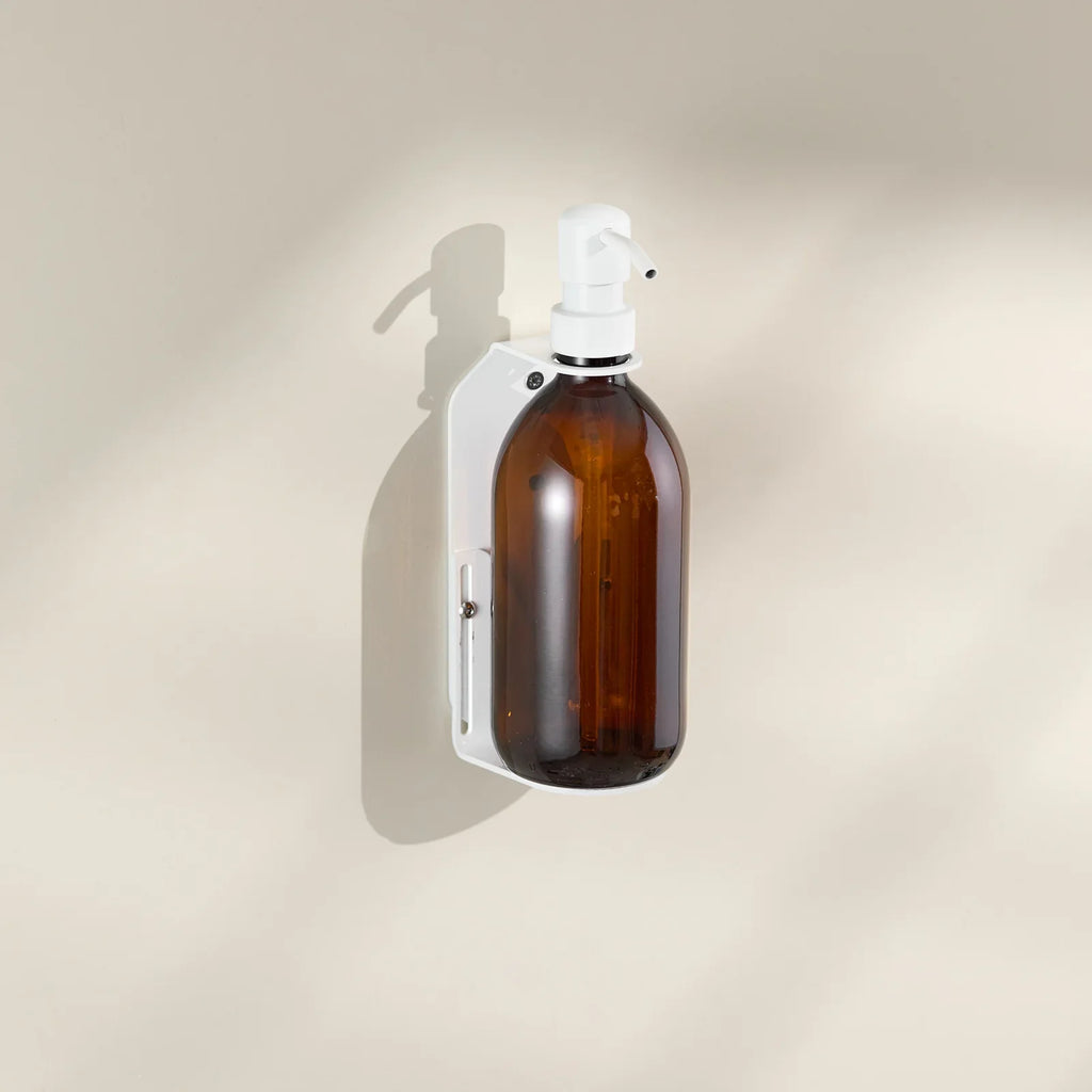 Brown glass spray bottle with white nozzle on a beige background