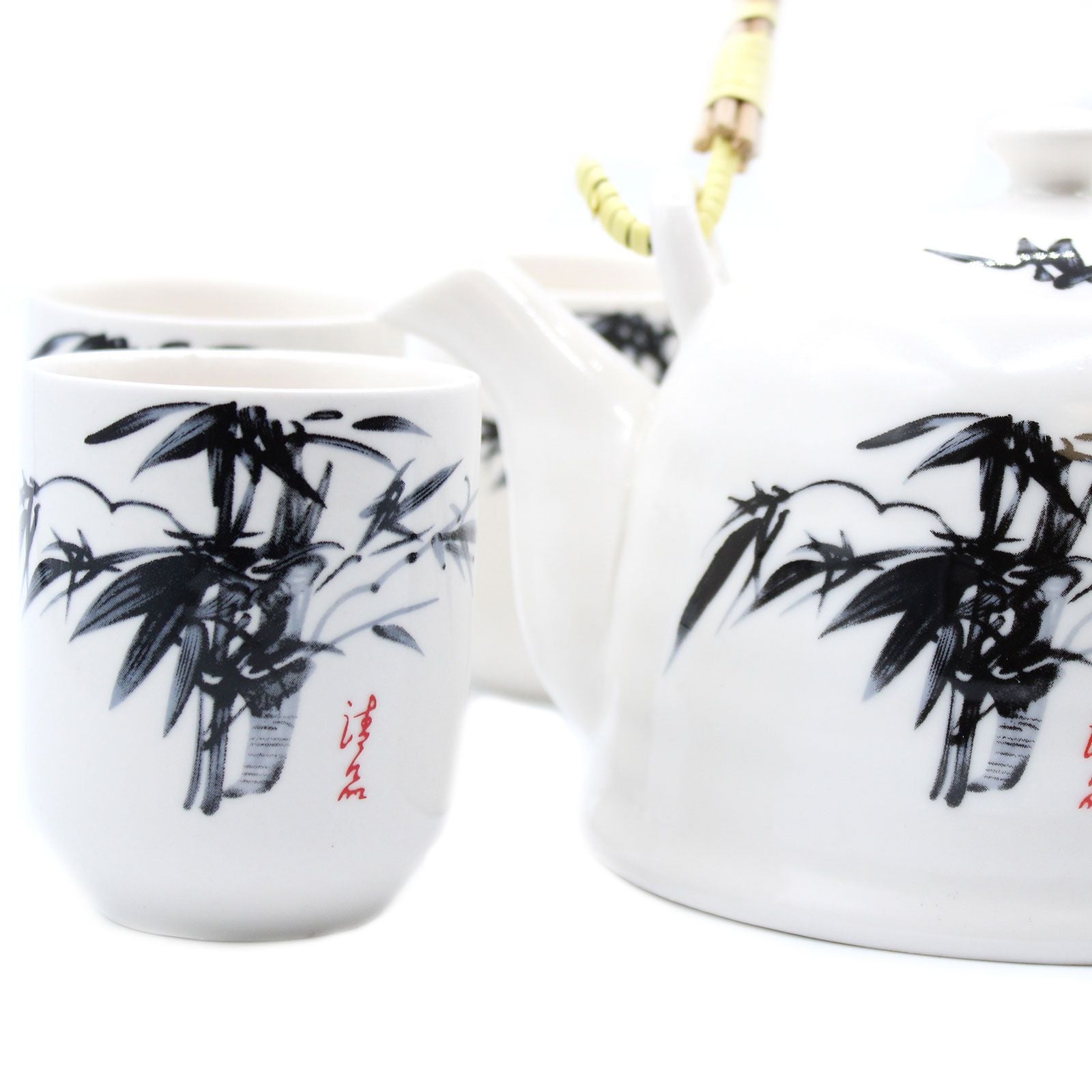 White ceramic teapot and cup set with black bamboo design on a white background