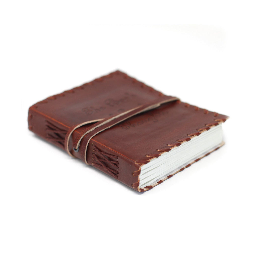 Brown leather-bound notebook with white pages on a white background