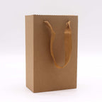 Brown paper gift bag with handles on a white background