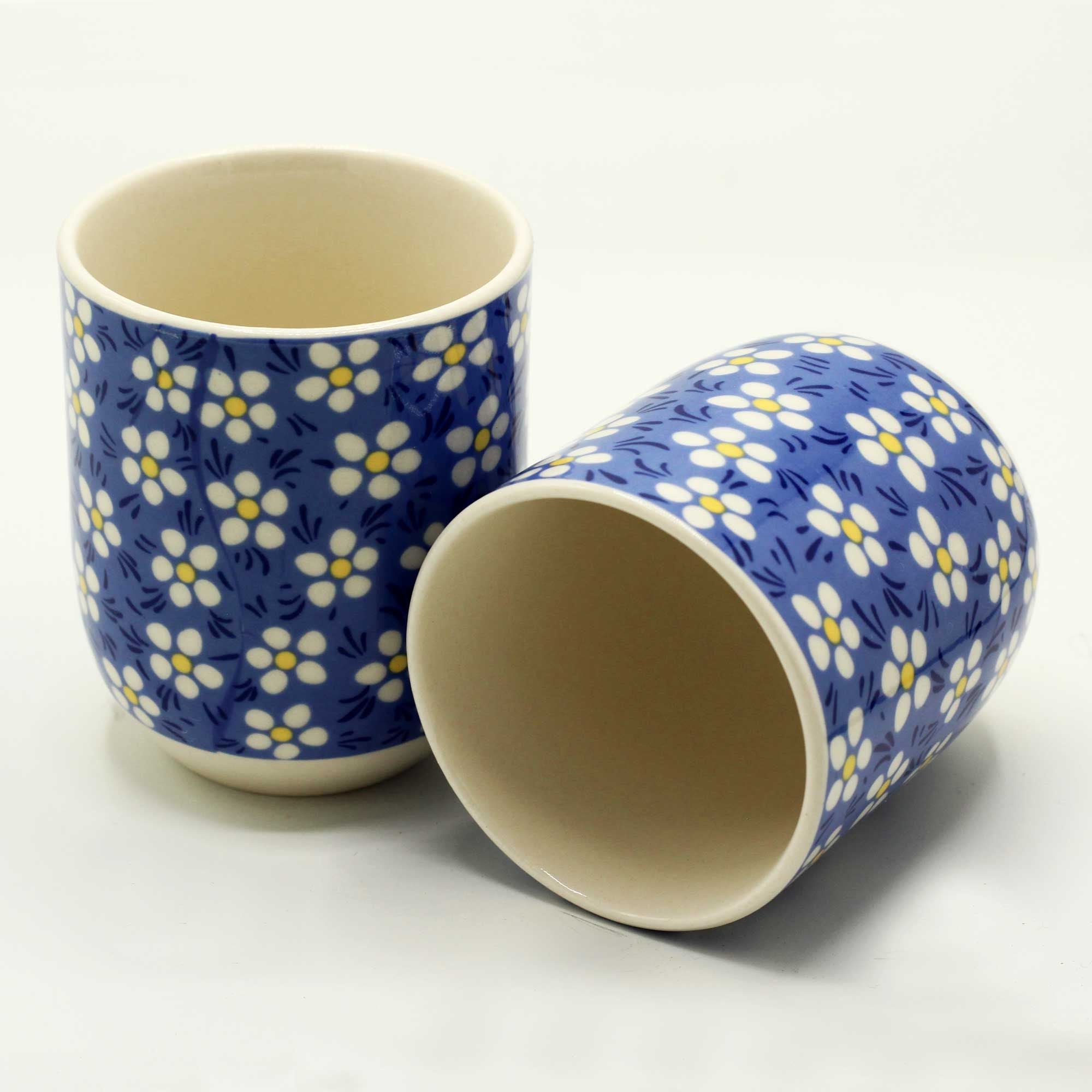 Two ceramic cups with blue floral pattern on a white background