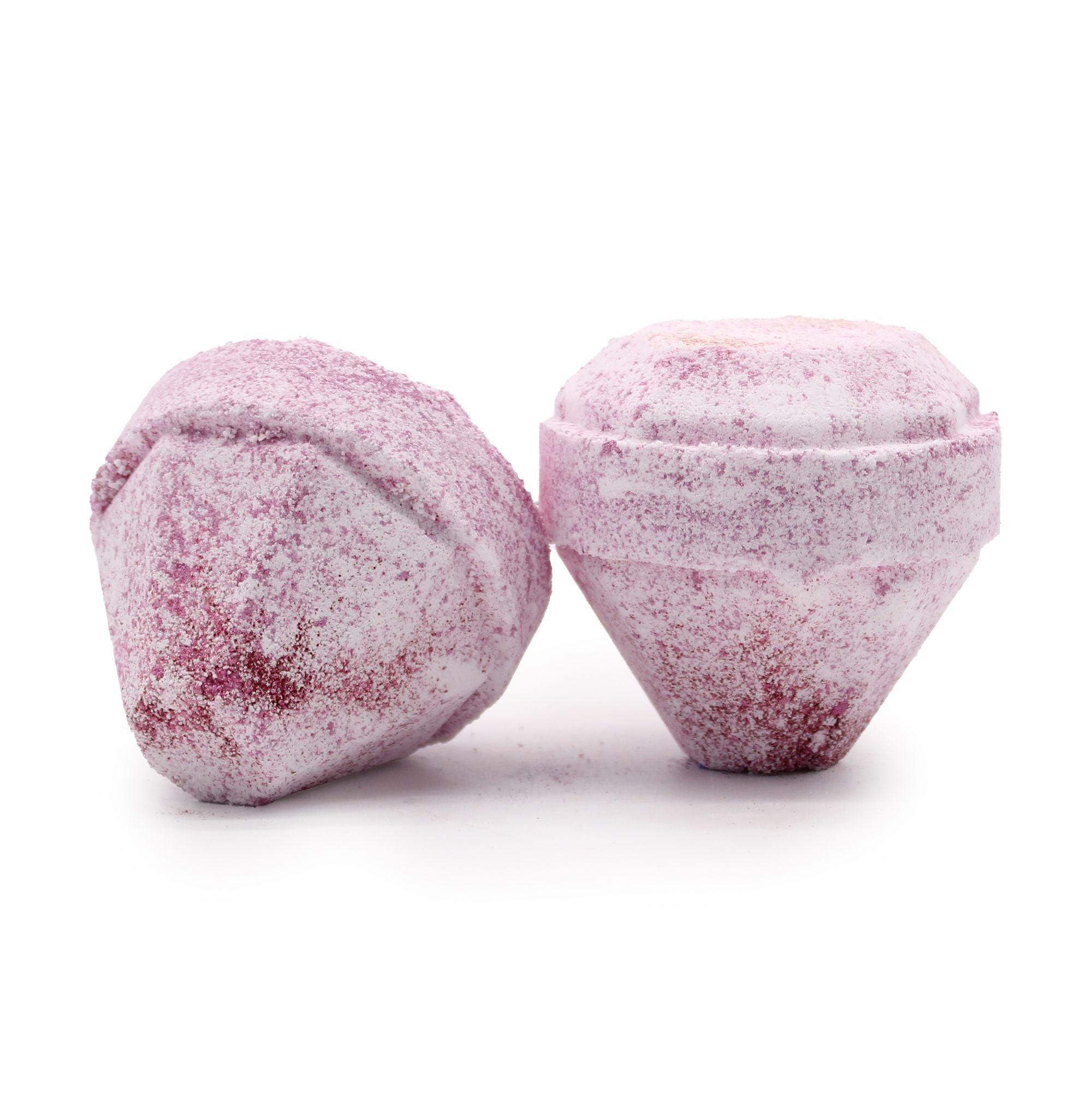 Close-up of two pink, faceted solid objects with a frosted, powdery surface on a white background, one upright and one resting on its side.