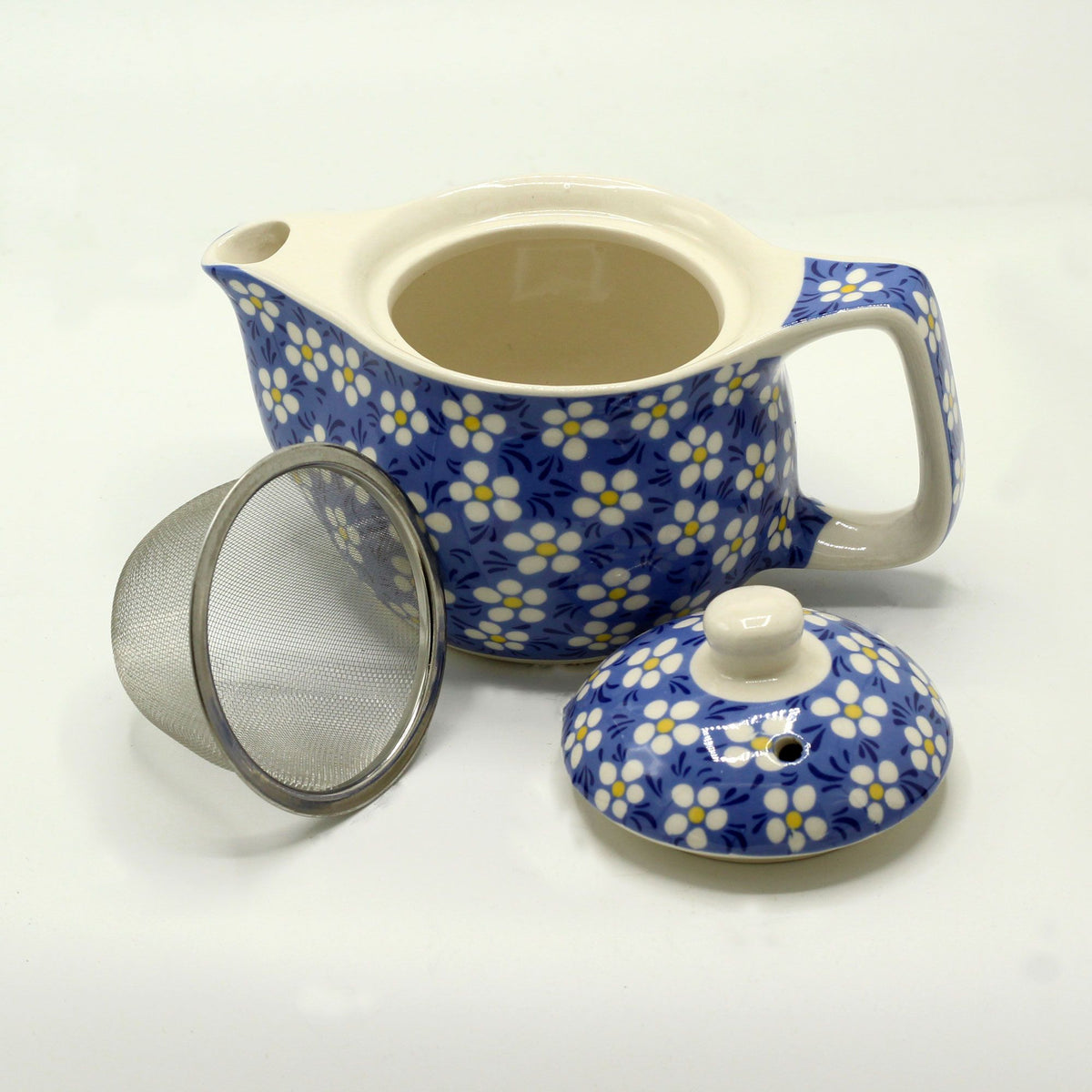 Ceramic teapot with floral pattern, mesh filter, and lid on a white background