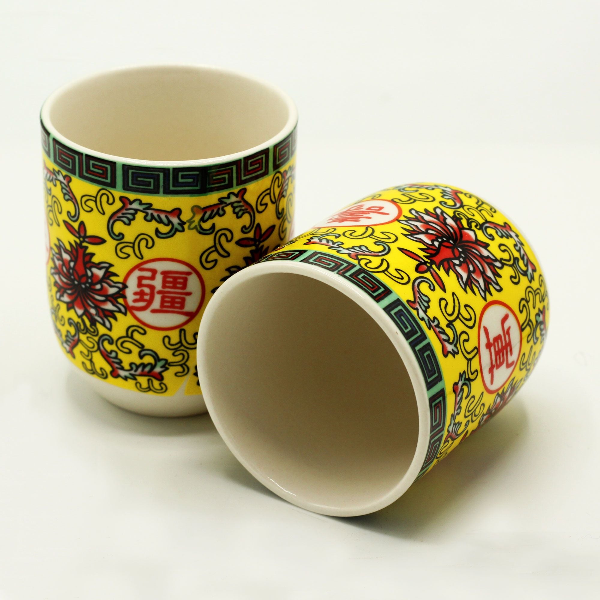 Two ceramic cups with colorful floral patterns on a white background