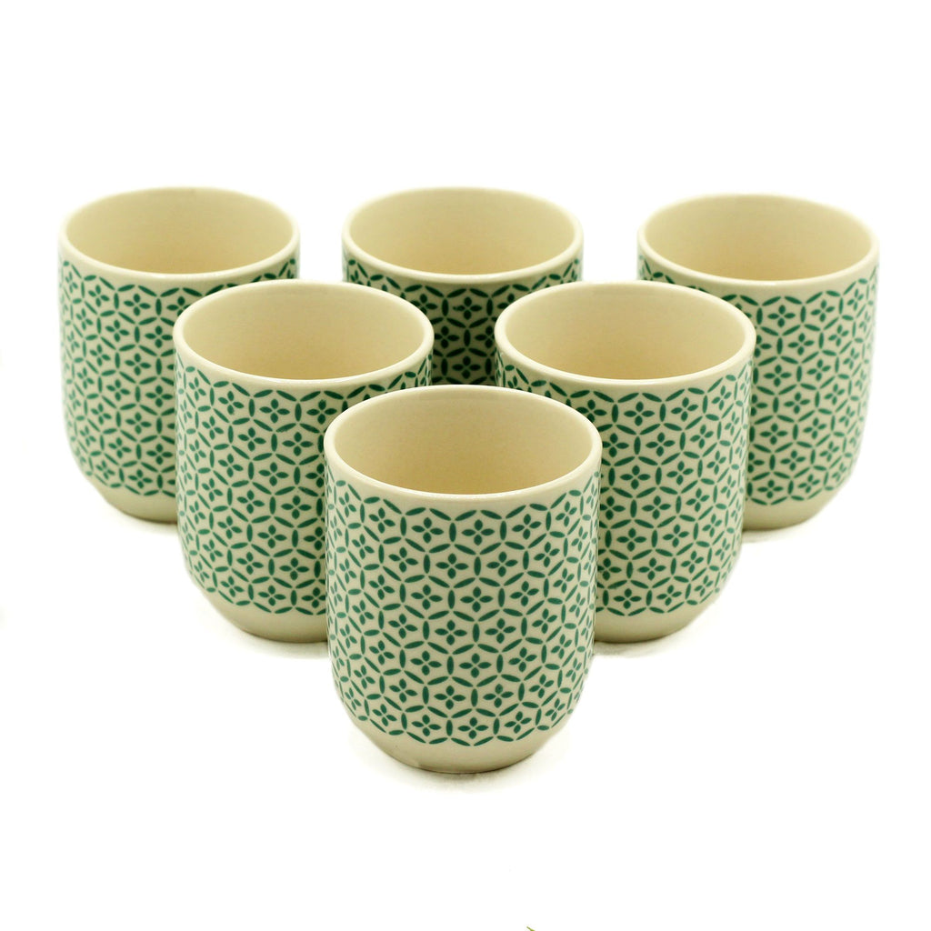 Set of six ceramic cups with green geometric pattern on a white background