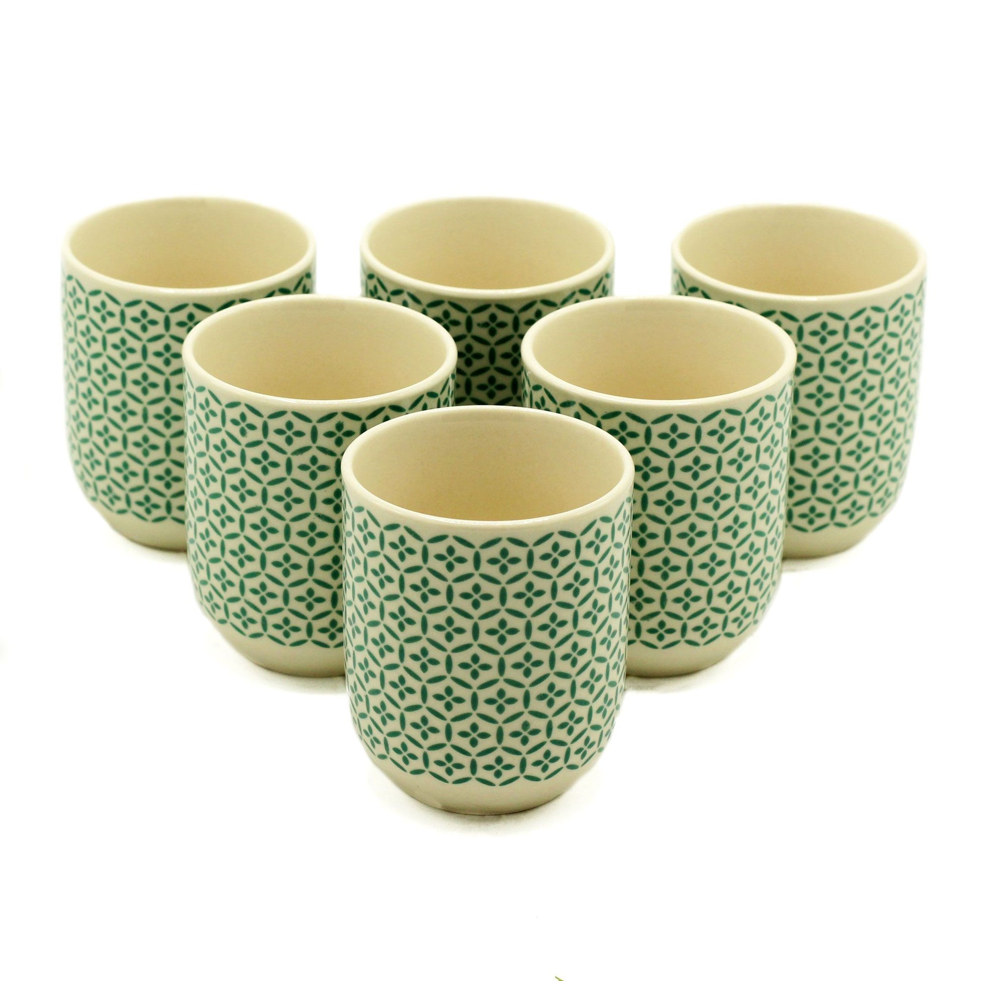Set of six ceramic cups with green geometric pattern on a white background