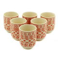 Set of six ceramic cups with red patterns on a white background