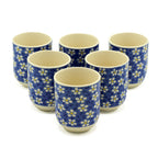 Set of six ceramic cups with blue floral pattern on a white background