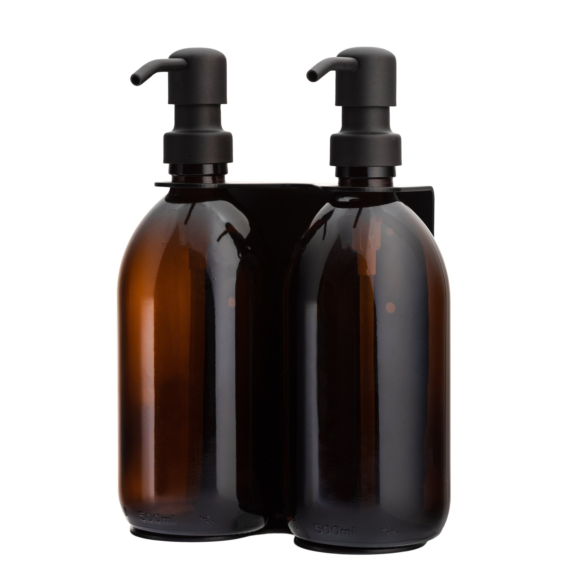 Two amber glass bottles with black pumps in a holder on a white background
