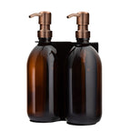 Two amber glass bottles with bronze pumps on a white background