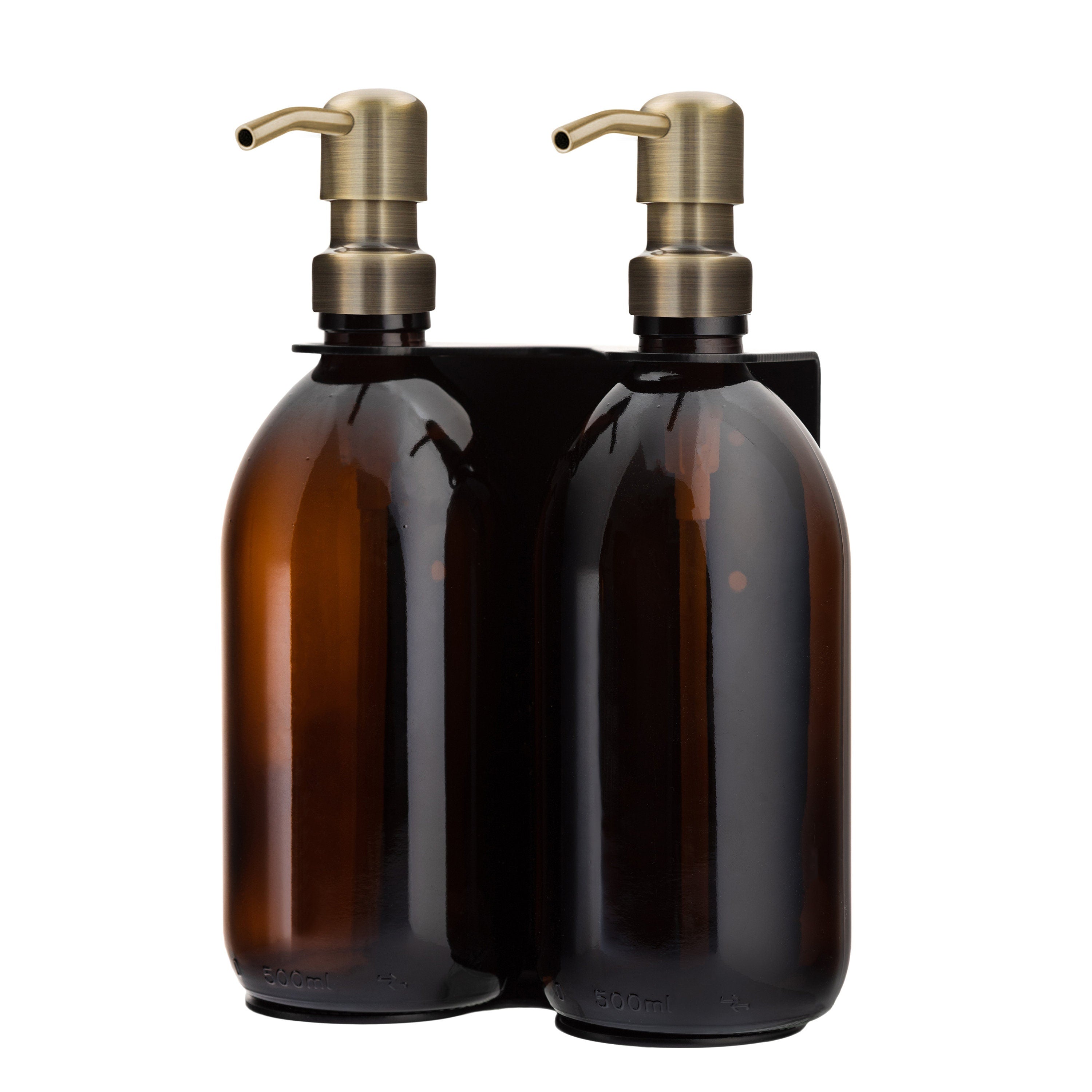 Two amber glass bottles with bronze pumps on a white background