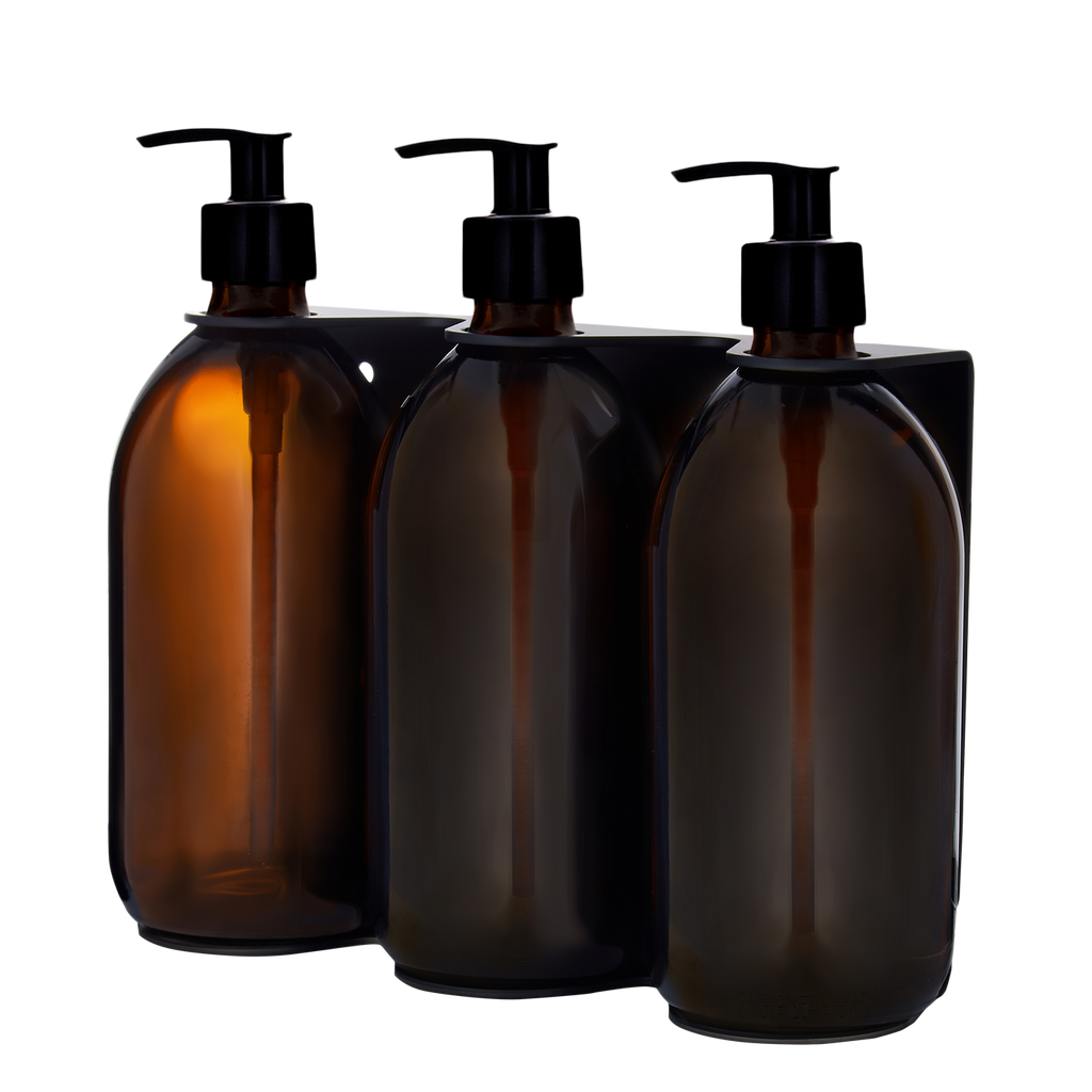 Three amber glass bottles with black pump dispensers on a white background