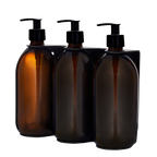 Three amber glass bottles with black pump dispensers on a white background