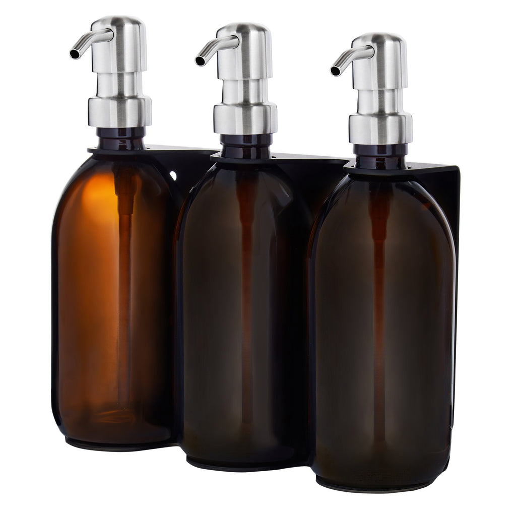 Three amber glass bottles with silver pump dispensers on a white background
