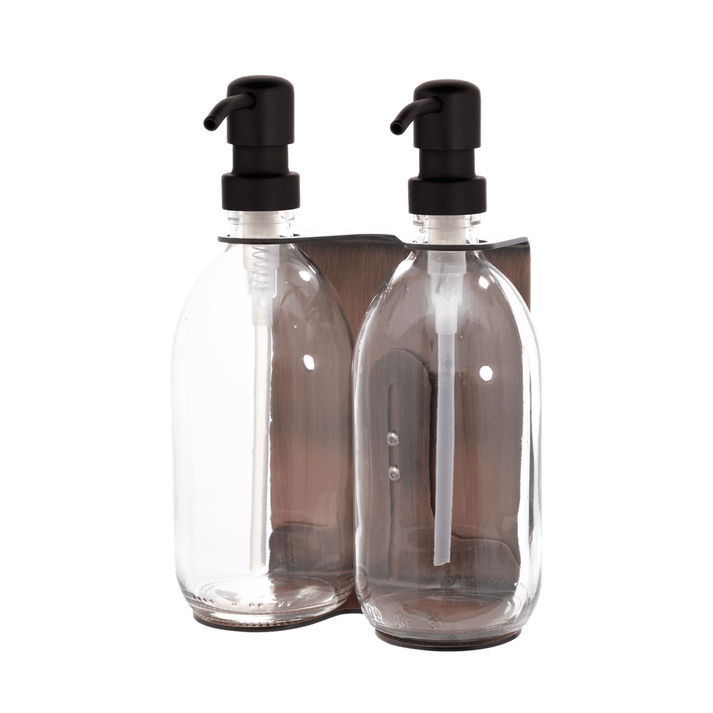 Two clear glass bottles with black pumps in a metal holder on a transparent background