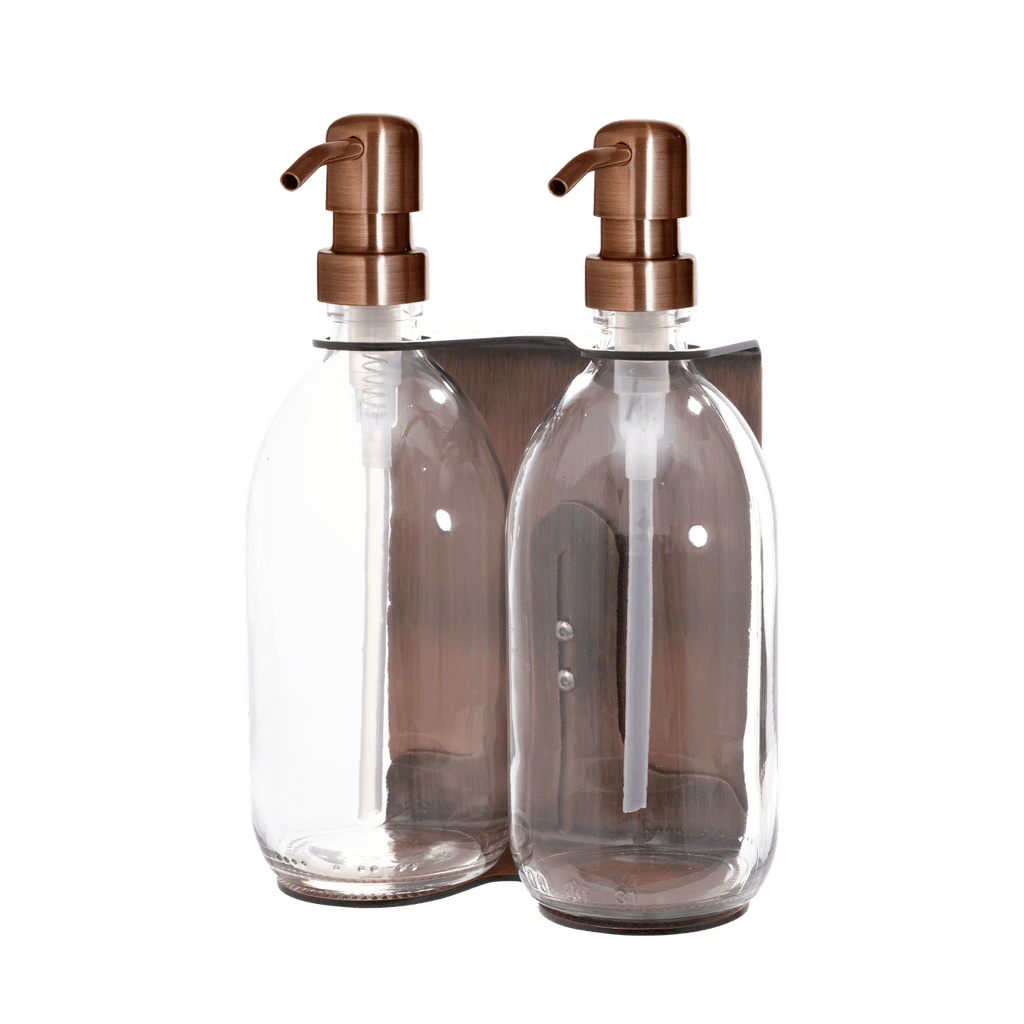 Two clear glass bottles with bronze pumps on a transparent background