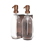 Two clear glass bottles with bronze pumps on a transparent background