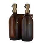 Two brown bottles with gold dispensers on a white background