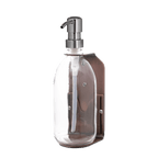 Clear glass bottle with pump on a dark green background