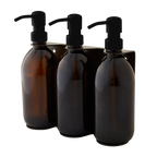 Three amber glass bottles with black pumps on a white background