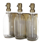 Three clear glass bottles with gold pumps on a white background