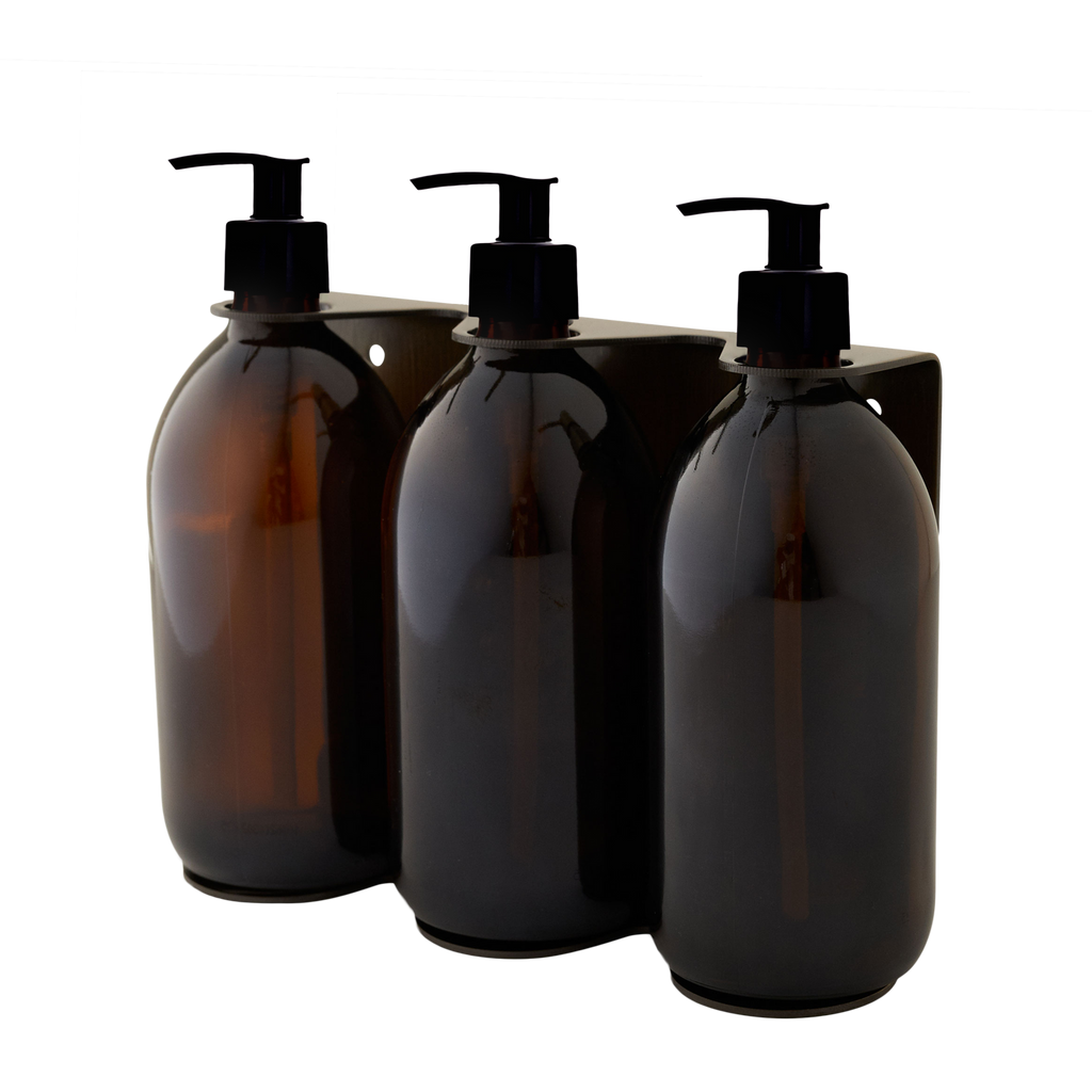 Three amber glass bottles with pump dispensers on a white background