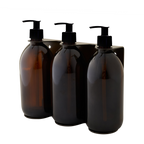 Three amber glass bottles with pump dispensers on a white background