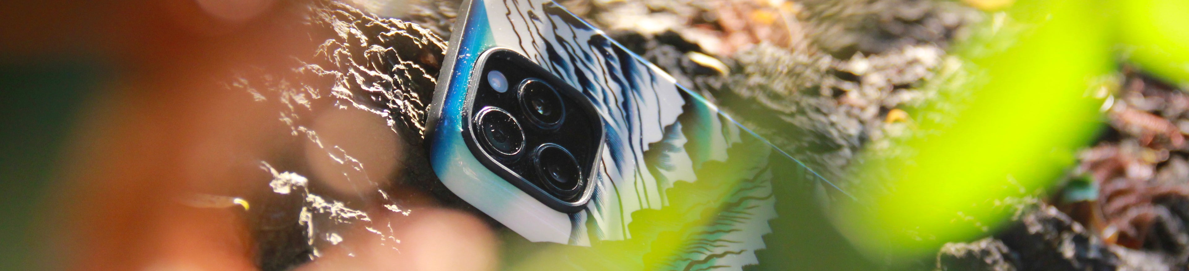 iPhone 16 pro phone case with a design of a person surfing, held by a hand with a blurred background | MVB STUDIO STORE
