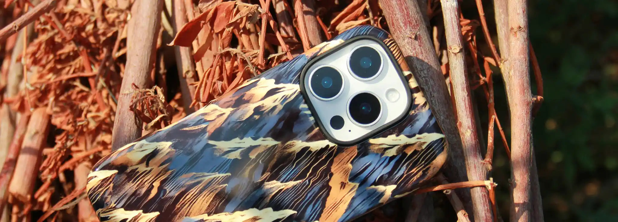 iPhone 16 Pro phone case from MVB STUDIO official store with camouflage pattern on a natural background