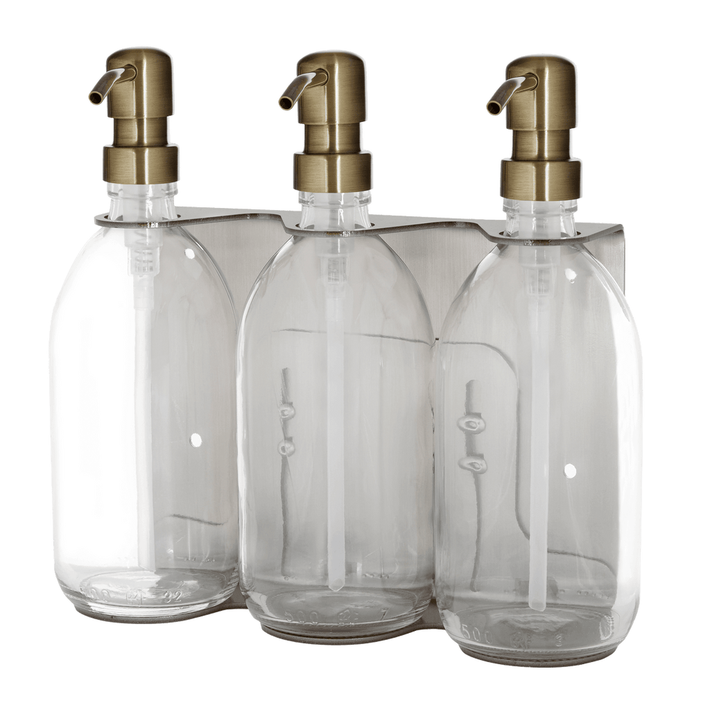 Three clear glass bottles with gold pumps on a transparent background