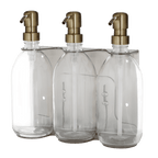 Three clear glass bottles with gold pumps on a transparent background