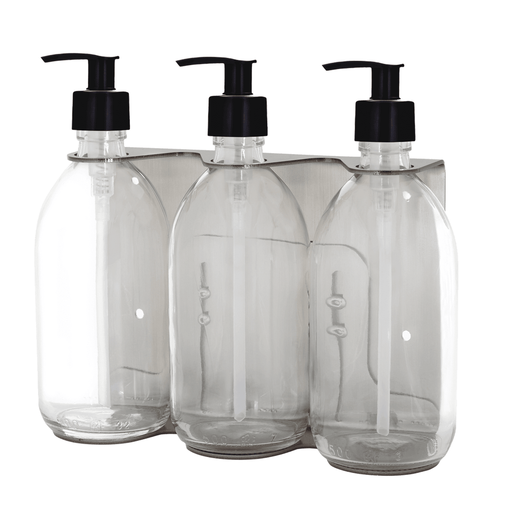 Three clear plastic bottles with black pump dispensers on a transparent background