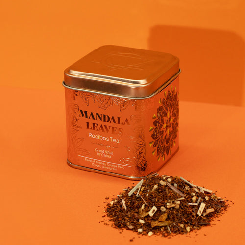 Mandala Leaves Rooibos Tea tin with tea leaves on an orange background