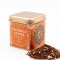 Tea tin labeled 'Mandala Leaves Rooibos Tea' with tea leaves spilling out on a white background